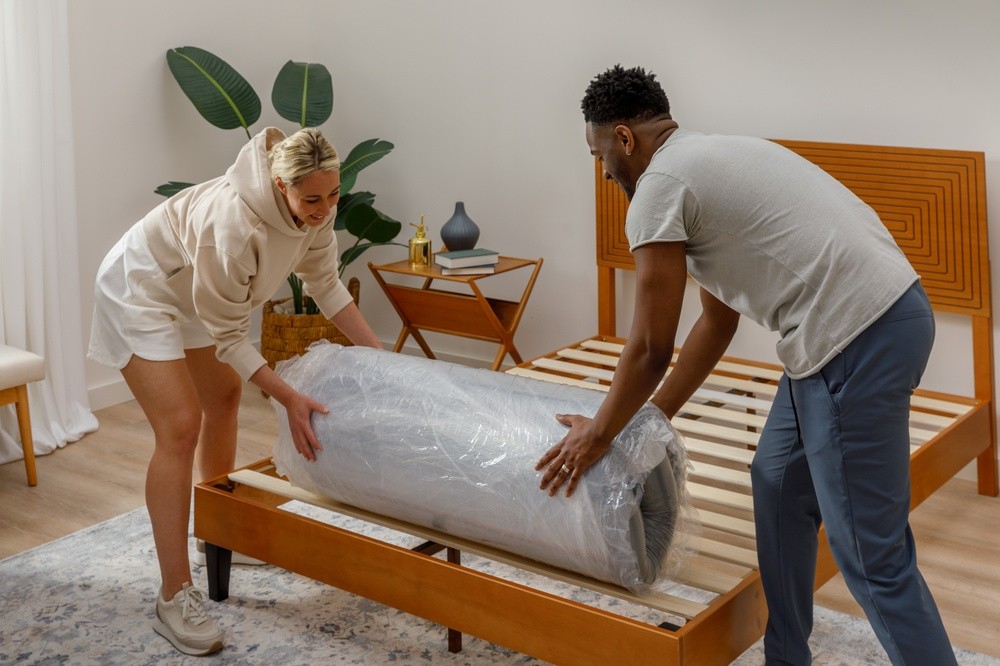 Couple unrolling Serenity Mattress